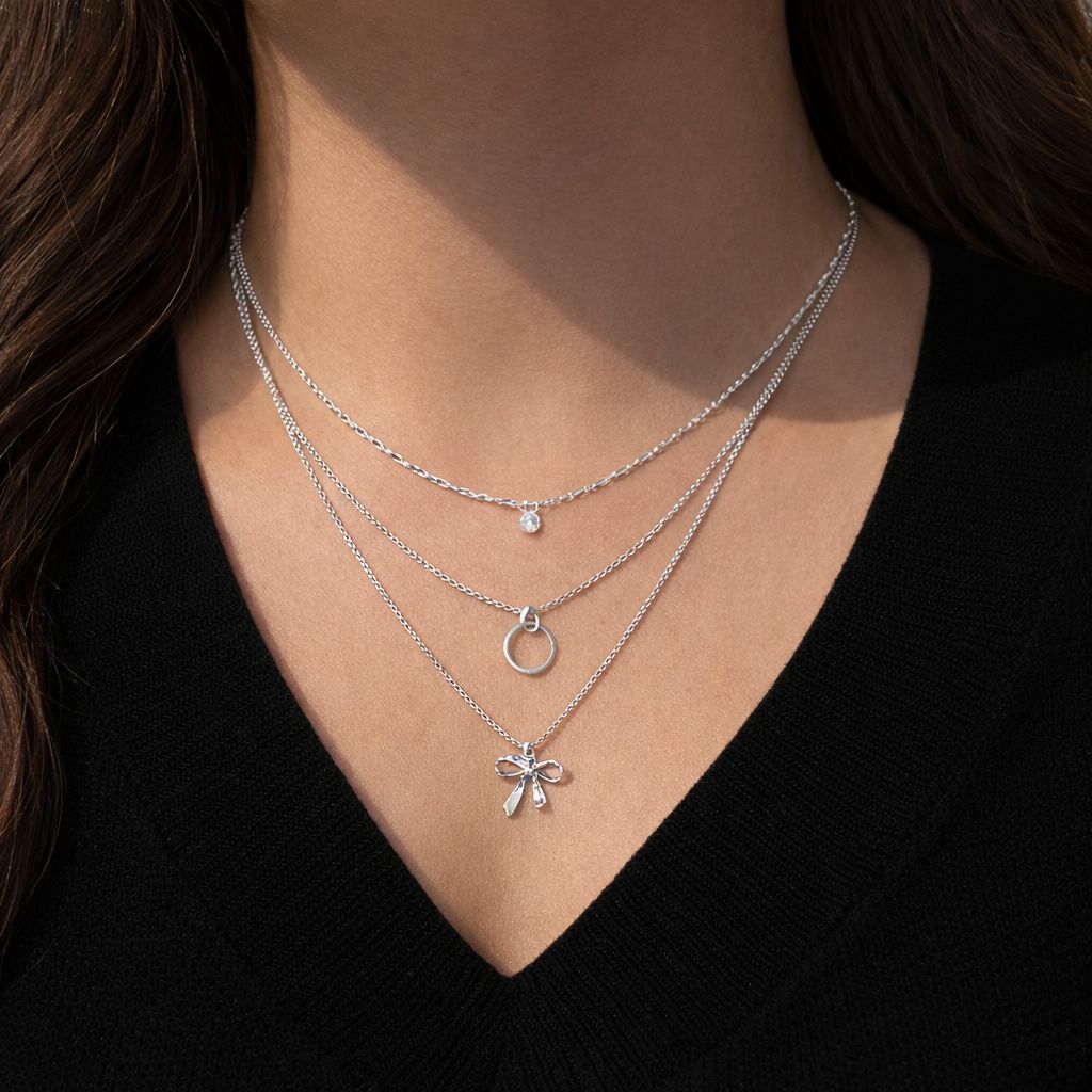 silver layered necklace with crystal circle and bow pendant