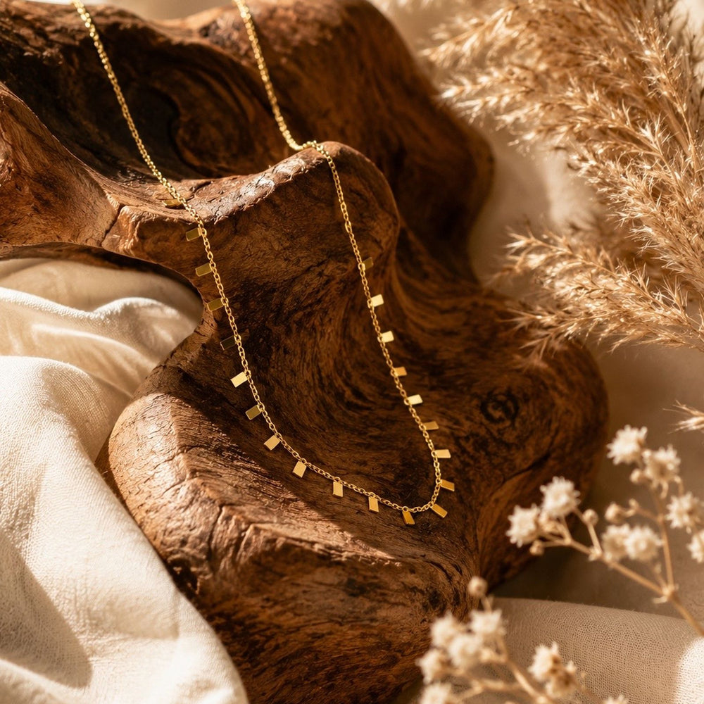 Gold-tone charm necklace with geometric dangling accents for women